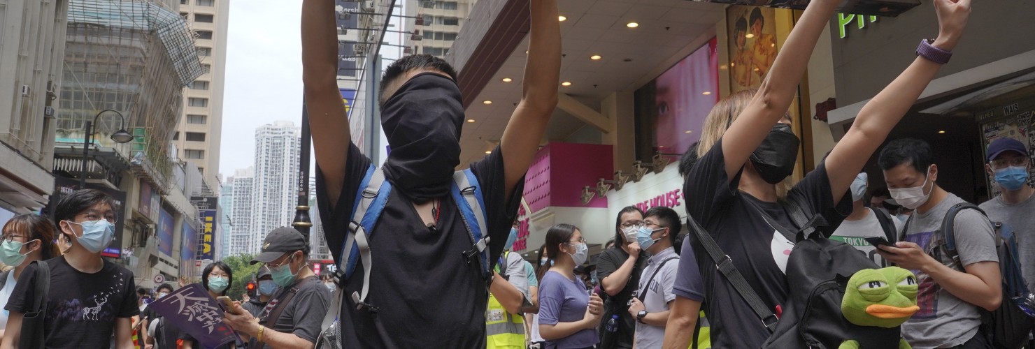 Protesters gesture with five fingers, signifying the "Five demands - not one less" as they march along a downtown street during a pro-democracy protest against Beijing's national security legislation in Hong Kong, Sunday, May 24, 2020. picture alliance / AP Photo