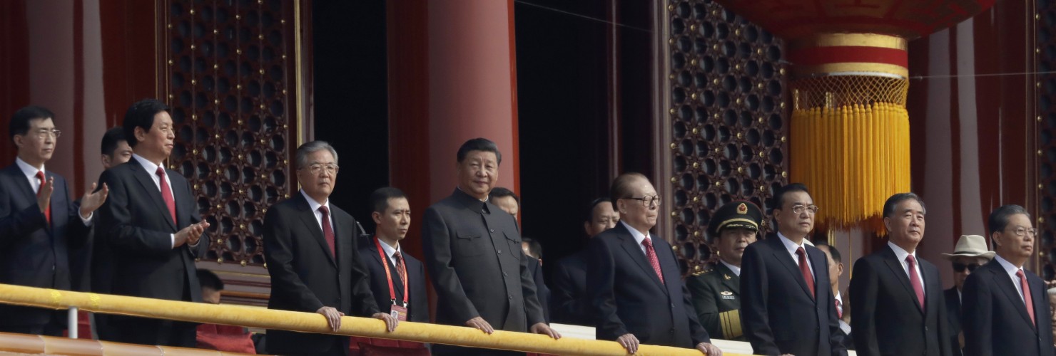 Chinese President Xi Jinping, center, stands with other Chinese leaders to watch a parade as Communist Party celebrates its 70th anniversary in Beijing, Tuesday, Oct. 1, 2019