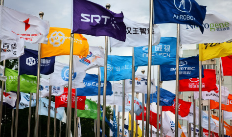 Factory flags of famous Chinese enterprises flutter in the wind under the blue sky in front of the square of the permanent site of the Zhongguancun Forum in Beijing, China, May 14, 2024.