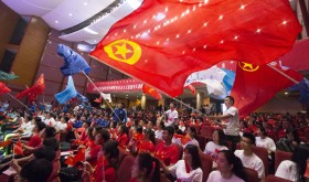 Young Chinese students from local universities wave flags of China and the Communist Youth League of China during a theme event to celebrate the upcoming 100th anniversary of the May Fourth Movement in Hohhot