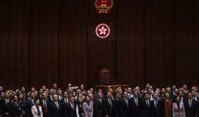 Hong Kong's Chief Executive John Lee, fifth foreground left, pose for photographs with lawmakers following the passing of the Basic Law Article 23 legislation at the Legislative Council in Hong Kong, Tuesday, March 19, 2024. 